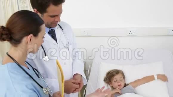 生病的小女孩和护士和医生躺在床上视频的预览图