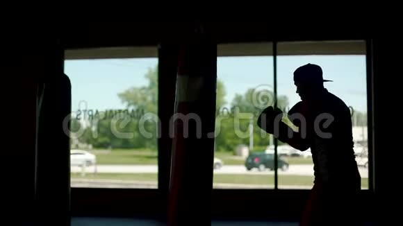 体育男子剪影正在拳击馆练习踢腿慢动作中弹视频的预览图