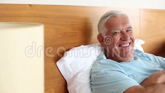 躺在床上对着镜头微笑的老人视频的预览图