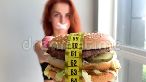 饮食一个女人想吃汉堡的画像但一张粘着的嘴一种饮食观念不健康的食物一种意志视频的预览图