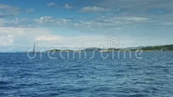 帆船漂浮在海上背景海岸线视频的预览图