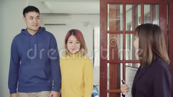 快乐的年轻亚洲夫妇和房地产经纪人一位性格开朗的年轻人和妻子一起坐在办公桌前签署一些文件视频的预览图