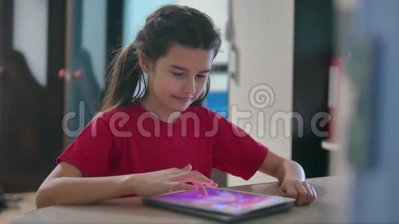少女在平板电脑网络游戏中玩女童社交媒体室内平板电脑互联网慢视频视频的预览图