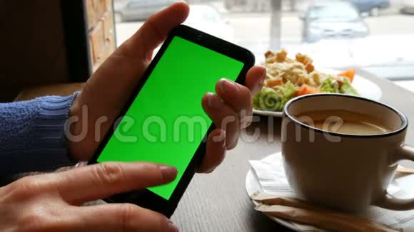 黑色智能手机上的Chroma键或绿色屏幕女性手中有精心修剪的指甲背景是视频的预览图