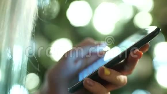 女性手拿着触摸屏手机和模糊的图像视频的预览图