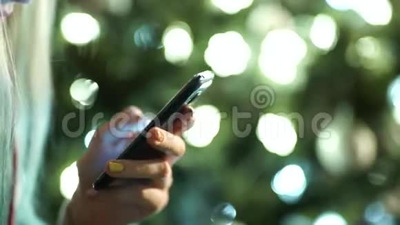 女性手拿着现代的触摸屏手机和模糊的图像视频的预览图