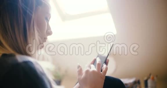 家里的女人用智能手机视频的预览图