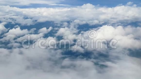 4K透过飞机窗户的鸟瞰蓝天背景下美丽的白云乘飞机旅行视频的预览图