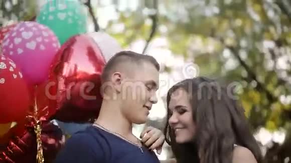 一对拿着气球在公园散步的夫妇视频的预览图