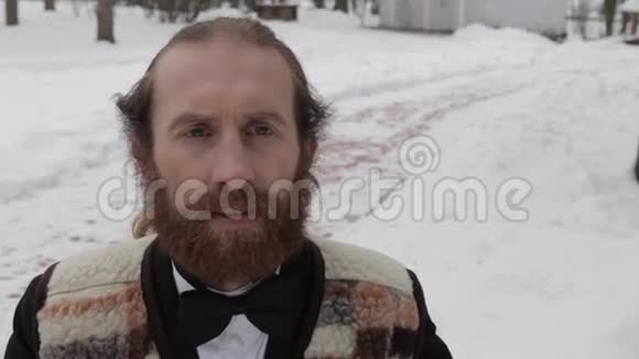 一个穿着西装系着领结穿着冬装留着胡子的电影人视频的预览图