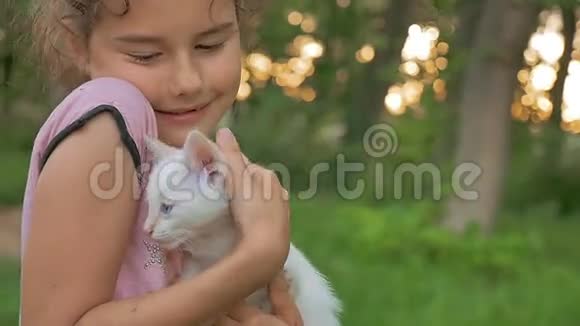 十几岁的黑发少女抱着小猫抱着她的猫喜欢户外活动视频的预览图