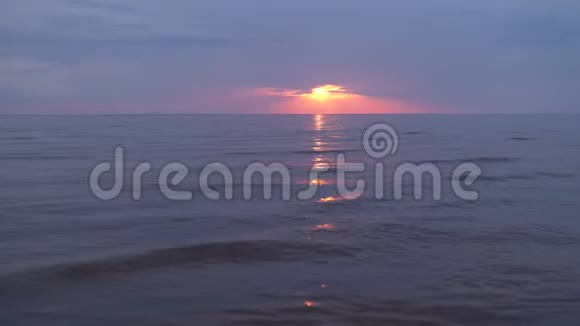 令人惊叹的黑暗风景生动的深红色日落在波罗的海有紫色和洋红色在小太阳下视频的预览图
