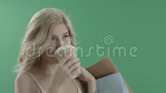 带着袋子喝咖啡的年轻女人视频的预览图