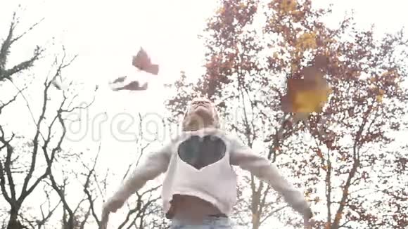 美丽的女孩在空中尽情地扔树叶视频的预览图