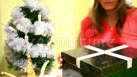 冬帽敞开式礼品盒附近的快乐年轻女子视频的预览图