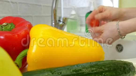 女人在厨房水槽的水龙头下洗新鲜蔬菜视频的预览图