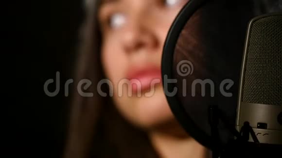 女歌手戴着耳机对着麦克风视频的预览图
