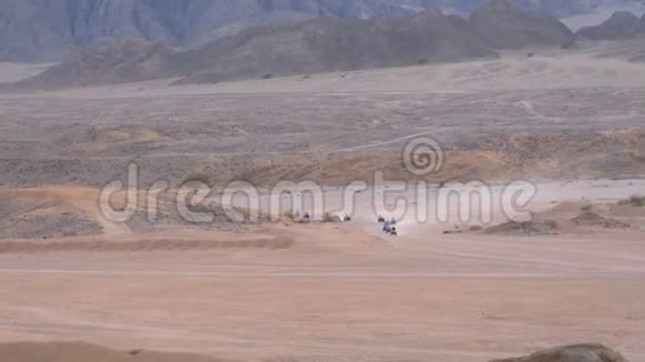 一列四人自行车骑在沙漠在埃及的山脉背景驾驶ATV视频的预览图