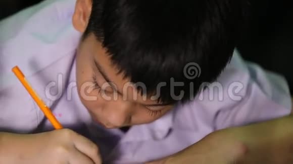 穿着学生制服的亚洲男孩在家用白纸作画视频的预览图