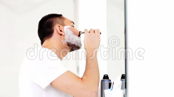 带安全剃刀的男人在浴室刮胡子视频的预览图