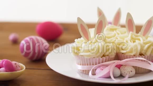 桌上有复活节彩蛋和糖果的纸杯蛋糕视频的预览图