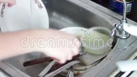 在厨房打扫脏盘子的人在厨房洗碗视频的预览图