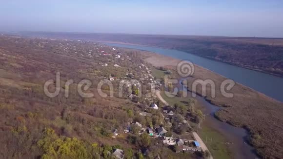飞越村庄和河流秋天飞过村庄和河流视频的预览图