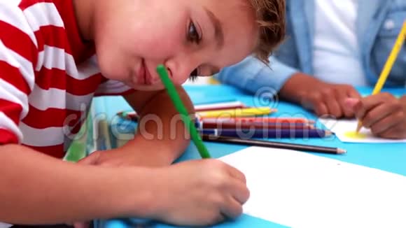 可爱的小男孩在教室里着色视频的预览图