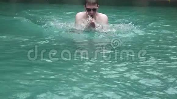 这位年轻的运动员在镜头前的一次蛙泳中漂浮在游泳池里视频的预览图