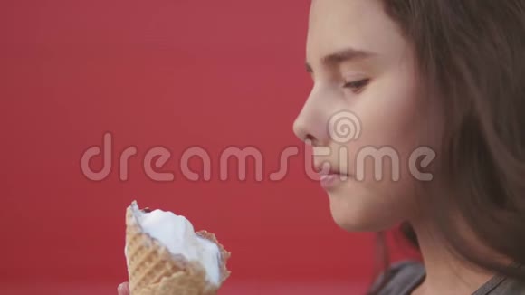 漂亮的女孩子吃慢动作视频护理瓶舔大冰淇淋在华夫饼锥与覆盆子视频的预览图