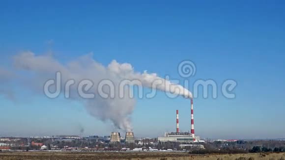 火力发电厂或地平线上有吸烟烟囱的工厂污染烟雾进入晴朗的蓝天视频的预览图