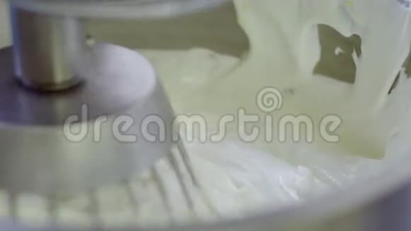 电动搅拌器将奶油倒入金属碗中视频的预览图