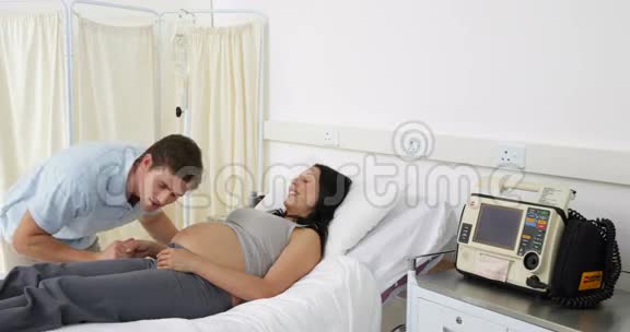 Brunette孕妇躺在床上与伴侣交谈视频的预览图