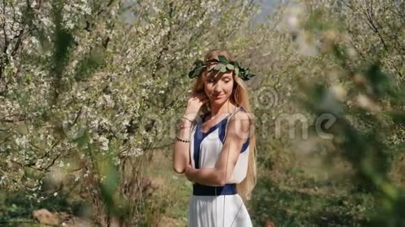 站在春暖花开的花园里穿着长裙的年轻美女视频的预览图