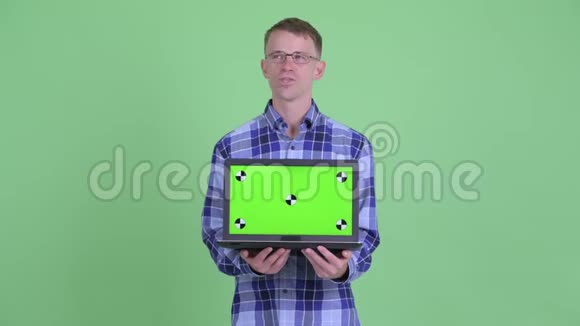 快乐的时髦男人在展示笔记本电脑时思考的肖像视频的预览图