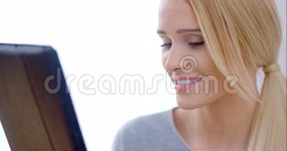 快乐的金发女孩用她的平板电脑视频的预览图