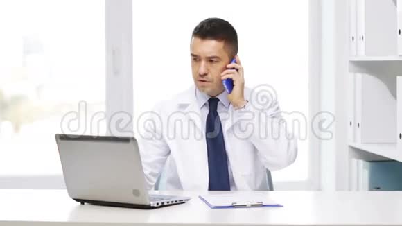 带手提电脑的医生打电话给智能手机视频的预览图