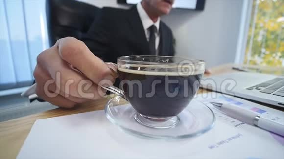 商人在看手提电脑屏幕时喝咖啡视频的预览图