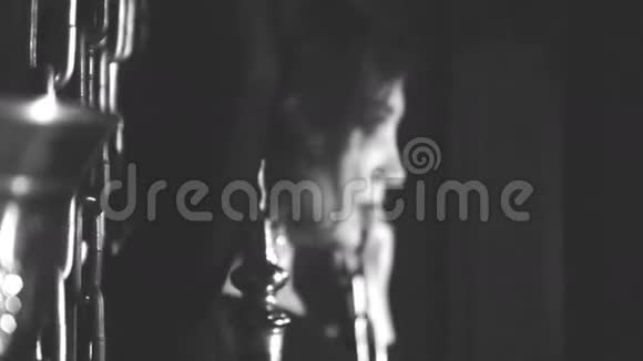 一个女孩在黑暗房间的锁链背景上的肖像黑白相间视频的预览图