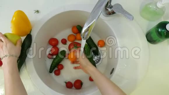 女人在厨房水槽的水龙头下洗新鲜蔬菜视频的预览图