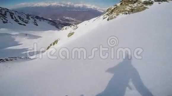 滑雪者从雪山之巅返回乡村晴天速度视频的预览图