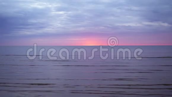 令人惊叹的黑暗风景生动的深红色日落在波罗的海有紫色和洋红色在小太阳下视频的预览图
