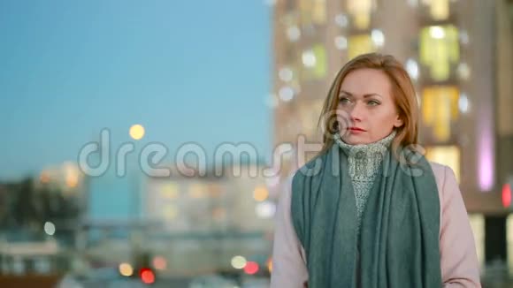 穿着粉红色外套的女孩走在摩天大楼背景下的现代城市视频的预览图