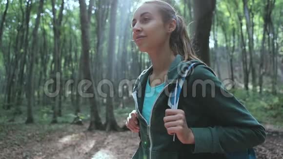 积极健康的女人在美丽的森林徒步旅行的肖像视频的预览图