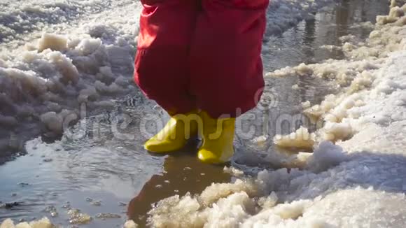 穿着雨靴的孩子在冰坑里跳视频的预览图