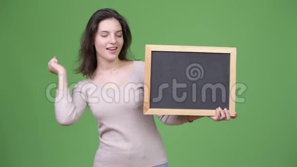 年轻快乐的美女举着黑板竖起大拇指视频的预览图