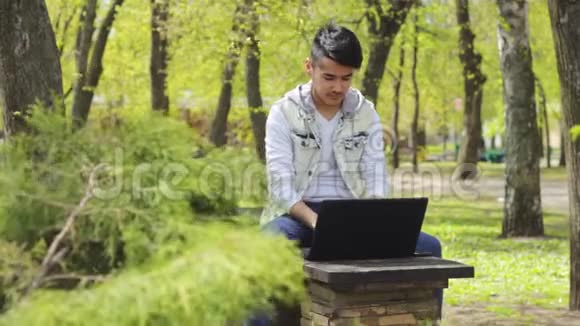 公园里有笔记本电脑的亚洲自由职业者视频的预览图
