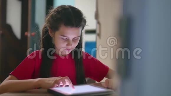 少女在平板电脑网络游戏中玩女童社交媒体室内平板电脑互联网慢视频视频的预览图