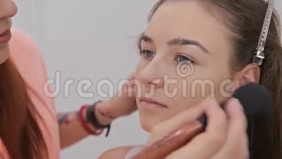 近距离射击专业化妆师将粉涂于女性面部视频的预览图