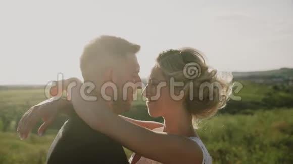 日落时在田野里的情人一对相爱的情侣闭上眼睛视频的预览图